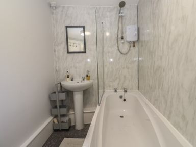 A bathroom with a bathtub and sink at 1 St. Day Road in Redruth
