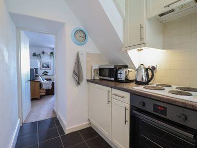 A kitchen with appliances and access to another room at Cnicht View in Porthmadog