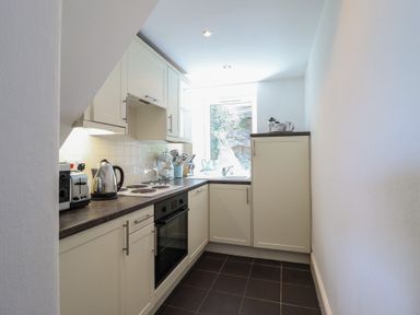 A kitchen with cabinets and appliances at Cnicht View in Porthmadog