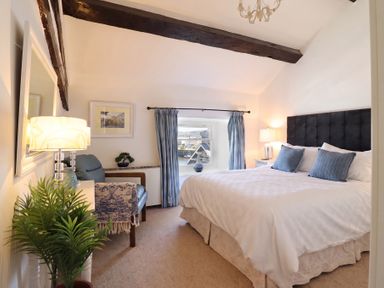 A bedroom with a bed, lamp, and chair at Cnicht View in Porthmadog
