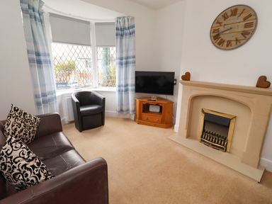 A living room with a sofa and television at 19 Dunstan View in Seahouses
