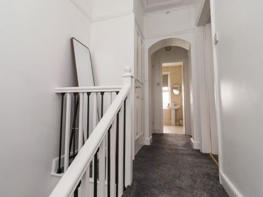 A hallway with a staircase and a bathroom in view at 19 Dunstan View Seahouses