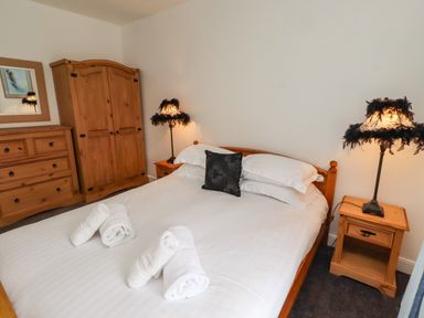 A bedroom with a bed and wardrobe at 19 Dunstan View in Seahouses