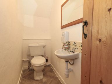 A bathroom with a toilet and sink at Greenwich Cottage in Burton Bradstock