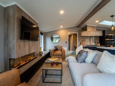 A living room with a sofa and television at Hideaway Lodge Llanfechell