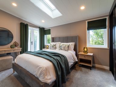 A bedroom with a bed and nightstand at Hideaway Lodge in Llanfechell