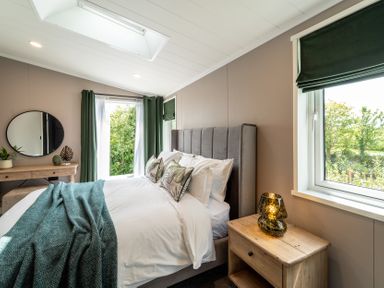 A bedroom with a bed and nightstand at Hideaway Lodge Llanfechell