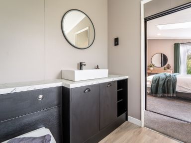 A bathroom with sink and mirror at Hideaway Lodge Llanfechell