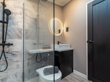 A bathroom with shower, toilet and sink at Hideaway Lodge in Llanfechell