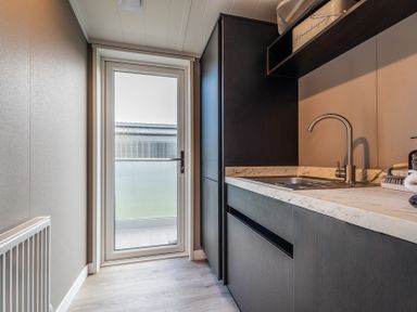A kitchen with a sink and a door at Hideaway Lodge Llanfechell