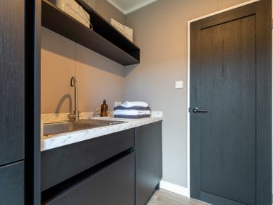 A laundry room with a sink and towels at Hideaway Lodge Llanfechell