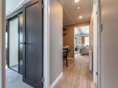 A hallway with doors and a desk at Hideaway Lodge in Llanfechell
