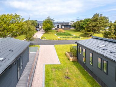 A view of houses and a grassy area at Hideaway Lodge in Llanfechell