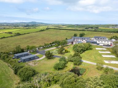 A landscape with buildings and greenery at Hideaway Lodge in Llanfechell