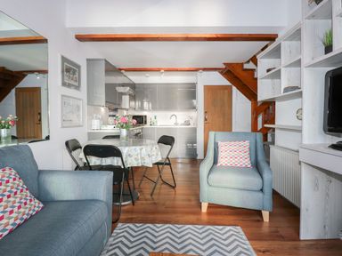 A living room with a sofa and dining area at Seafarer's Haven in Porthmadog