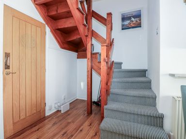 A staircase with wooden steps and a door at Seafarer's Haven in Porthmadog
