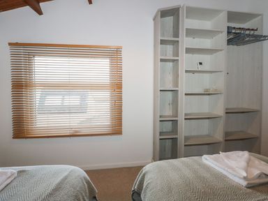 A bedroom with a window and shelving units at Seafarer's Haven in Porthmadog