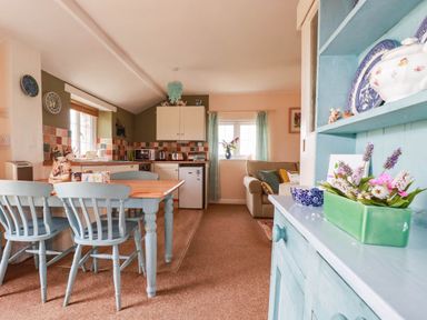 A kitchen with table and chairs and cabinets at The Granary in 