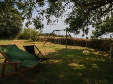A garden with a swing set and deck chair at The Granary 