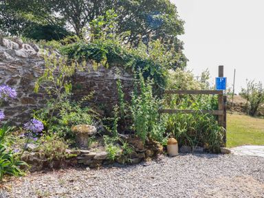 An outdoor area with a stone wall and plants at The Granary in 