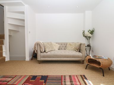 A snug with a sofa and a staircase at Tower View Cottage in Lympstone