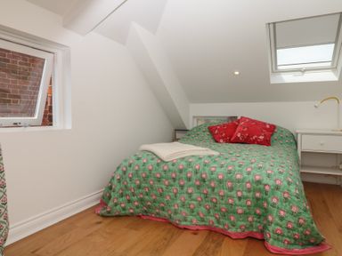 A bedroom with a bed and a desk at Tower View Cottage in Lympstone