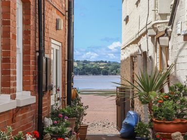 A view between buildings towards the beach at Tower View Cottage in Lympstone