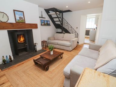 A living room with a fireplace and staircase at The Lookout in Redruth