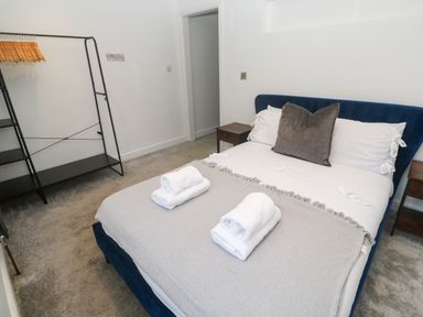 A bedroom with a bed and a hanger rack at The Lookout in Redruth