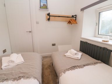 A bedroom with two beds and a window at The Lookout in Redruth