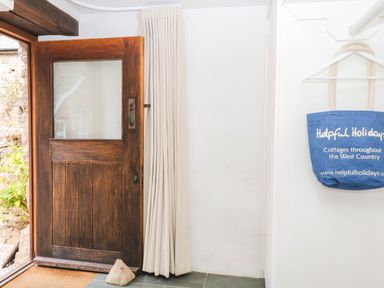 An entrance with a wooden door and a bag at The Hayloft at Manaton