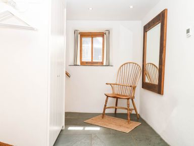 An entryway with a chair and mirror at The Hayloft at Manaton