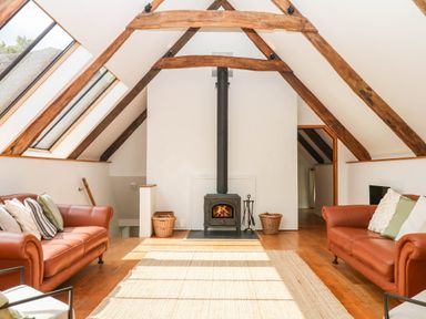 A living room with sofas and a stove at The Hayloft at Manaton