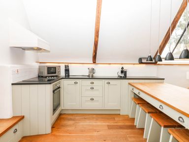 A kitchen with appliances and a dining table at The Hayloft at Manaton
