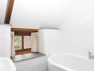 A bathroom with a bathtub and a window at The Hayloft at Manaton