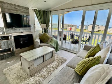A living room with a television and a coffee table at Craig Tara Holiday Park 101 Bay View Ayr
