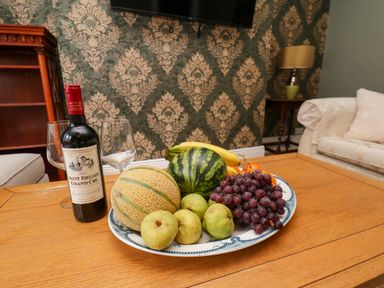 A table with fruits and wine in a living room at Lansdowne Grange in Bridlington