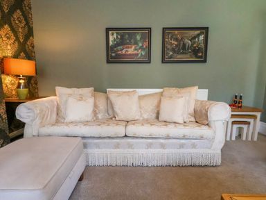 A living room with a sofa and artwork at Lansdowne Grange in Bridlington