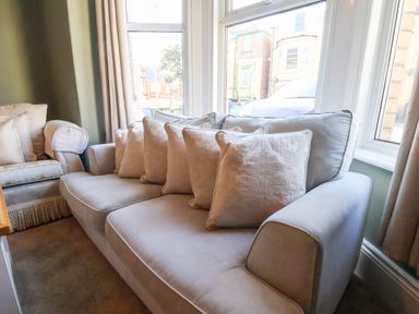 A living room with a sofa and cushions at Lansdowne Grange in Bridlington