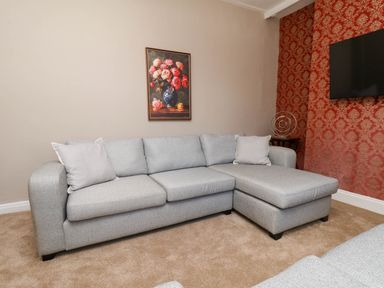 A living room with a sofa and a painting at Lansdowne Grange in Bridlington