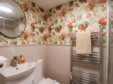 A bathroom with a toilet, sink, and towel rail at Lansdowne Grange in Bridlington