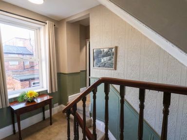 A staircase with a table and window at Lansdowne Grange in Bridlington