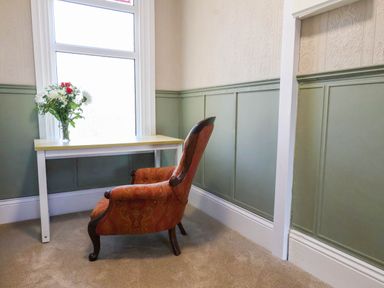 A study with a chair and table in front of a window at Lansdowne Grange in Bridlington