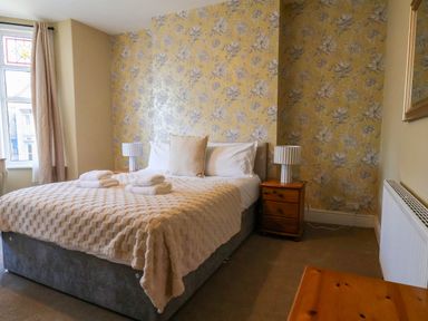 A bedroom with a bed and bedside table at Lansdowne Grange in Bridlington