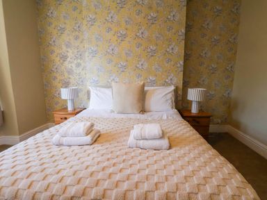 A bedroom with a bed and lamps at Lansdowne Grange in Bridlington