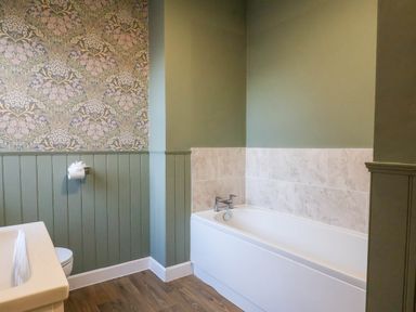 A bathroom with a bathtub and toilet at Lansdowne Grange in Bridlington