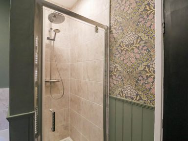 A shower with a glass door in a bathroom at Lansdowne Grange in Bridlington