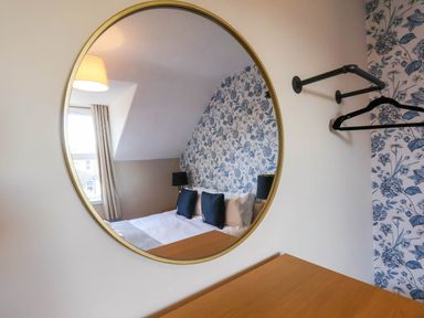 A bedroom with a mirror and bed at Lansdowne Grange in Bridlington