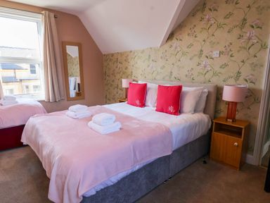 A bedroom with a bed and mirror at Lansdowne Grange in Bridlington