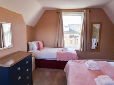 A bedroom with two beds and a dresser at Lansdowne Grange in Bridlington